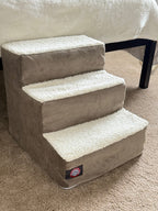 Grey sherpa pet stairs beside a bed