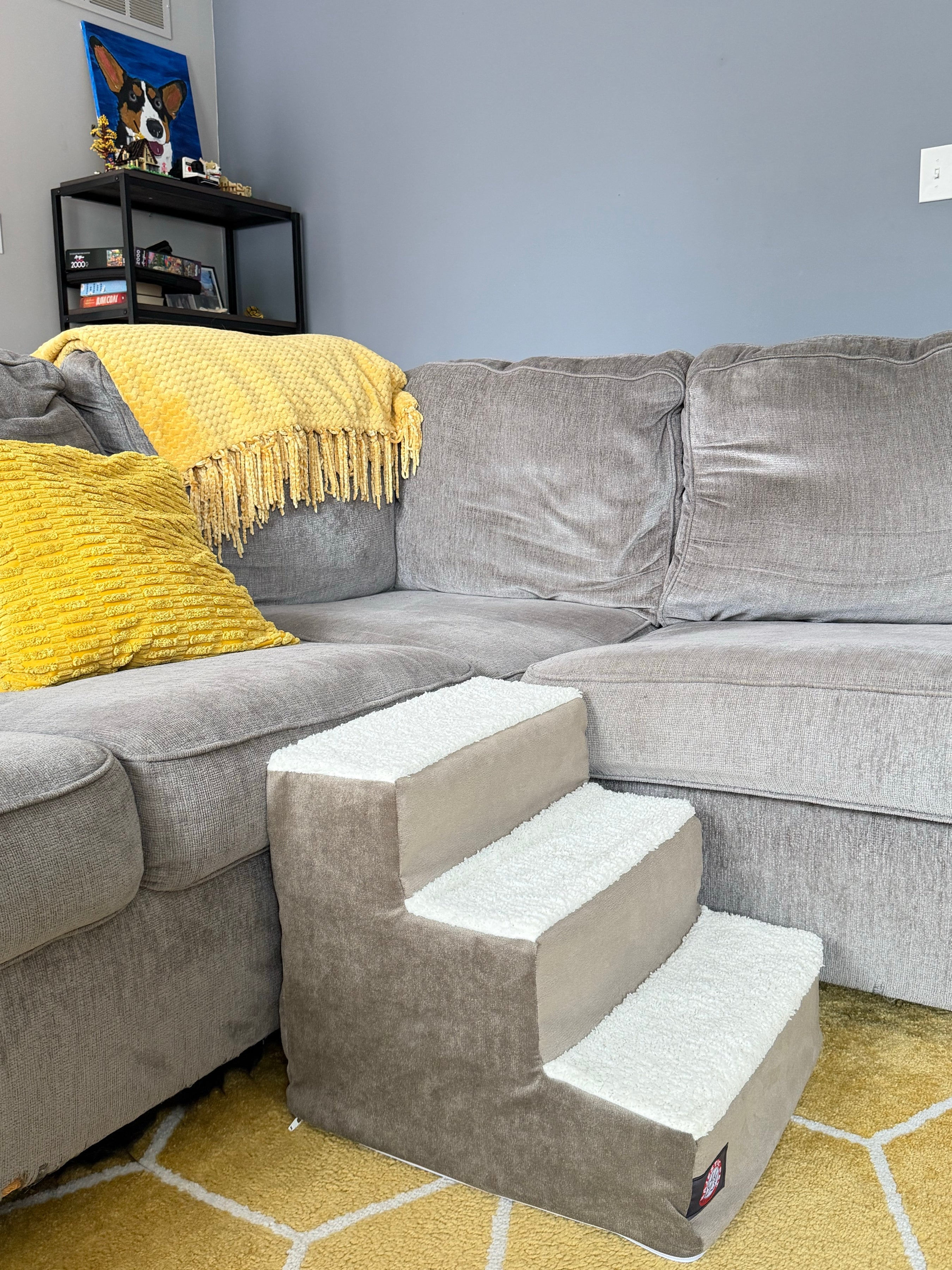 Grey sherpa pet stairs beside a sectional sofa